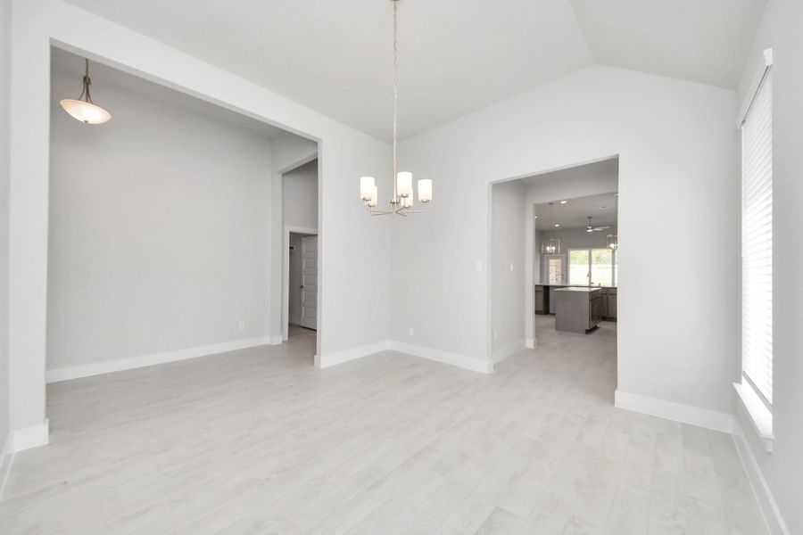 Craft enduring memories with loved ones around the table! This roomy dining area boasts stylish flooring, personalized paint, and is conveniently situated next to the family room and kitchen, fostering an open and inclusive ambiance. Sample photo of completed home with similar floor plan. Actual colors and selections may vary.