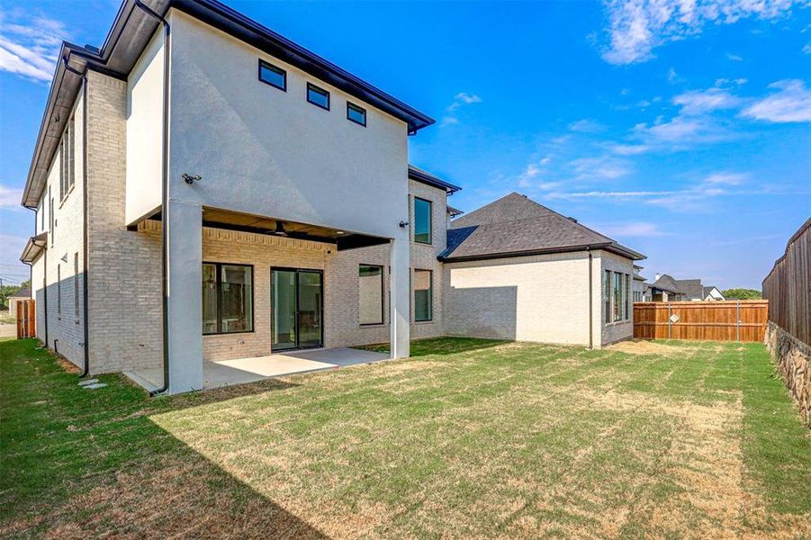 Back of property featuring a yard, ceiling fan, and a patio area