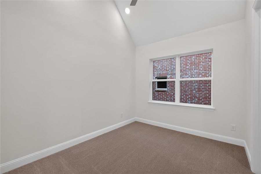 Vaulted ceiling room featuring neutral-toned walls, carpet flooring, a white-framed window, and recessed lighting Vaulted ceiling room featuring neutral-toned walls, carpet flooring, a white-framed window, and recessed lighting
