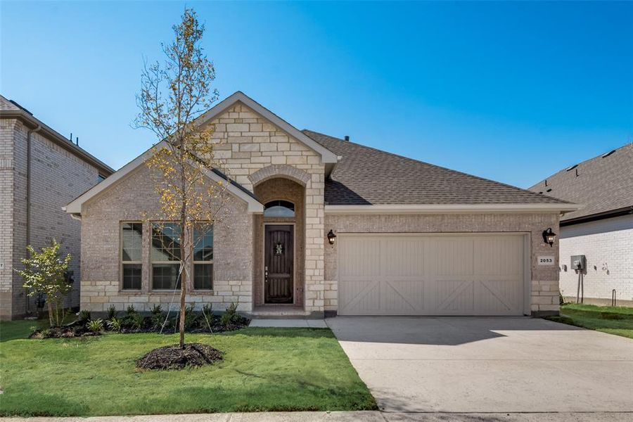 View of front facade featuring a garage and a front lawn