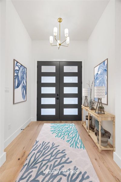 Foyer entrance with a chandelier and engineered white oak wood finished floors. Virtually staged. Foyer entrance with a chandelier and engineered white oak wood finished floors. Virtually staged.