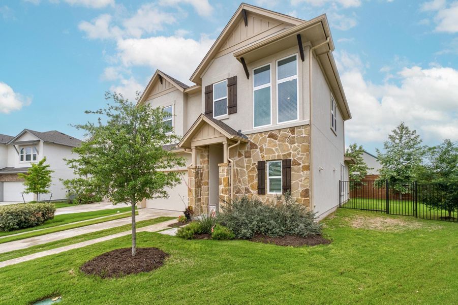 View of front facade with a garage, fence, stone siding, board and batten siding, and driveway View of front facade with a garage, fence, stone siding, board and batten siding, and driveway