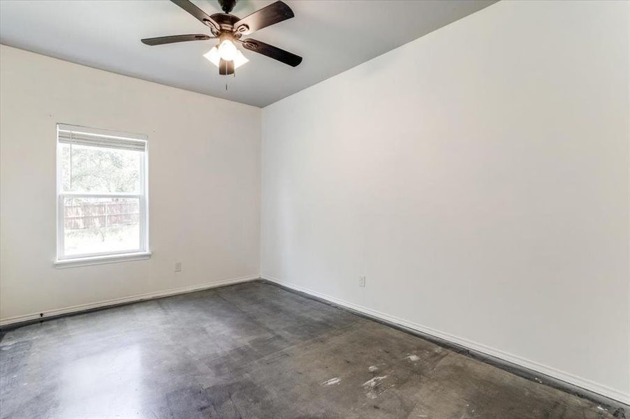 Room featuring a ceiling fan with integrated lighting, a double-hung window, and neutral wall tones