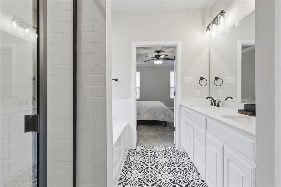 Full bathroom featuring ensuite bathroom, double vanity, a garden tub, and a shower stall