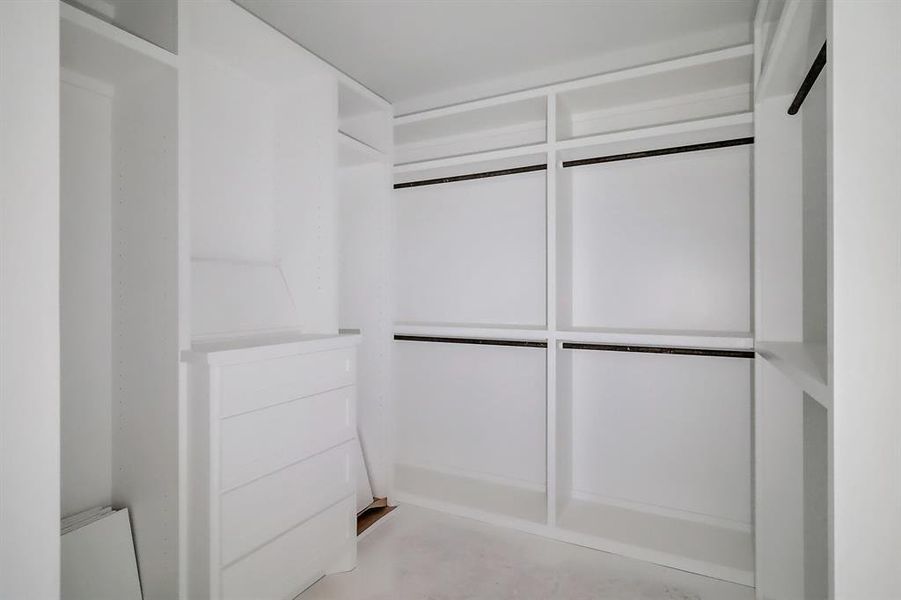 A custom walk-in closet provides plenty of space to organize and display your wardrobe.