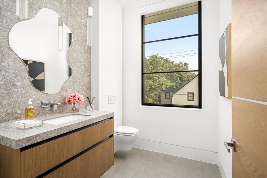 Second level powder bath. Sleek Milan stone adjacent to the gameroom and balcony. Second level powder bath. Sleek Milan stone adjacent to the gameroom and balcony.