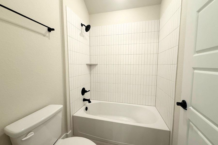 A pristine bath and shower area features modern tilework and sleek fixtures. A pristine bath and shower area features modern tilework and sleek fixtures.