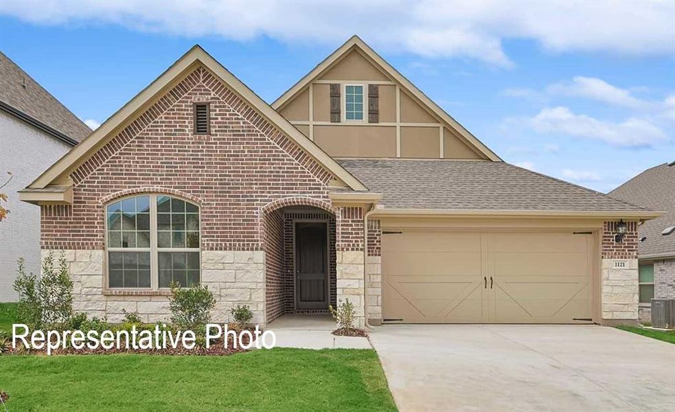 View of front of home with a garage and a front lawn