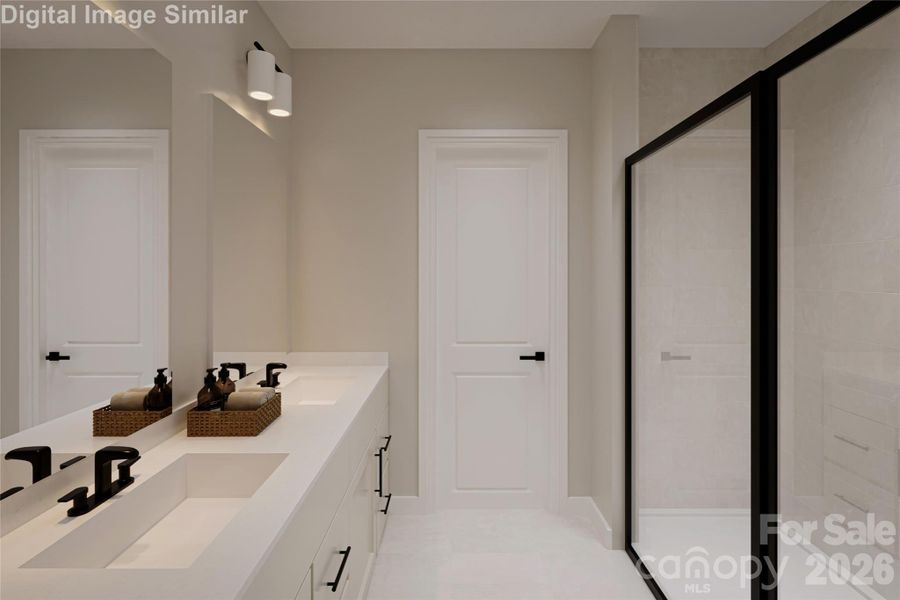 The ensuite bathroom features clean, modern lines and a sleek framed shower door — a perfectly balanced space that feels effortlessly refined.