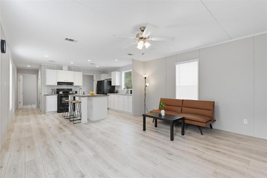 Living area featuring light wood finished floors, a ceiling fan, and recessed lighting Living area featuring light wood finished floors, a ceiling fan, and recessed lighting
