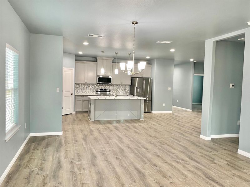 An open-concept living space with a contemporary kitchen and durable flooring.