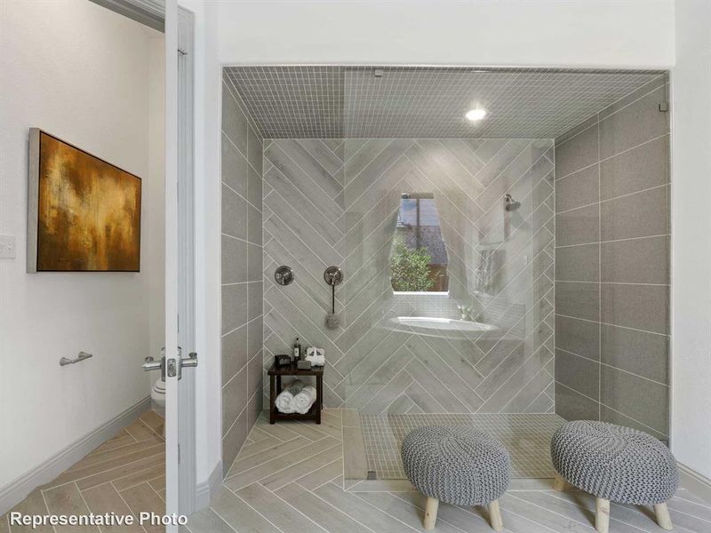 Bathroom with a tile shower and baseboards Bathroom with a tile shower and baseboards