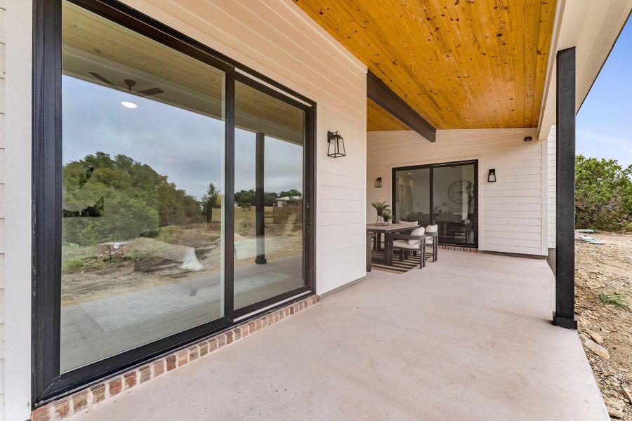 An inviting covered patio with a rich wood ceiling and ample space for outdoor dining. An inviting covered patio with a rich wood ceiling and ample space for outdoor dining.