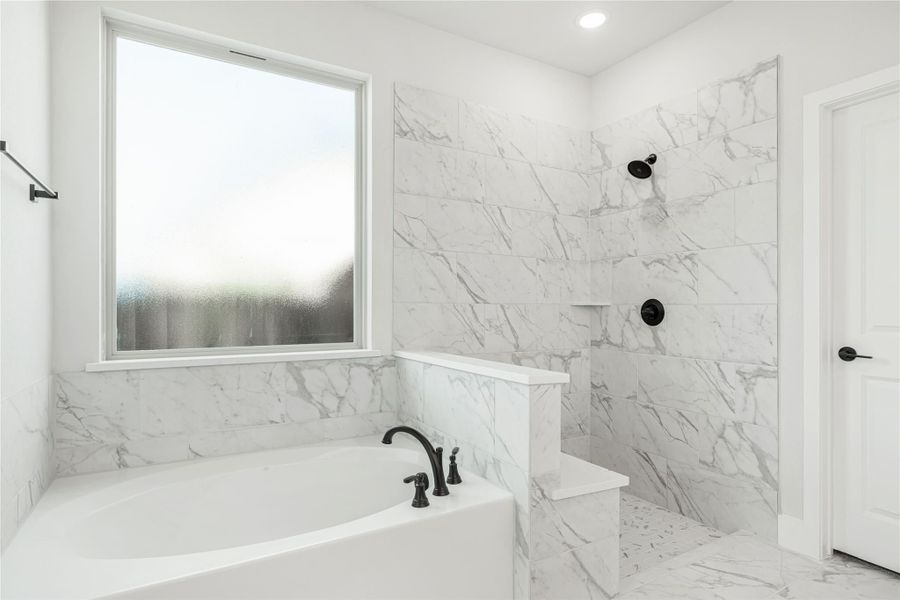 Master bathroom with soaking tub, walk-in shower, and white marble tile walls and floors Master bathroom with soaking tub, walk-in shower, and white marble tile walls and floors