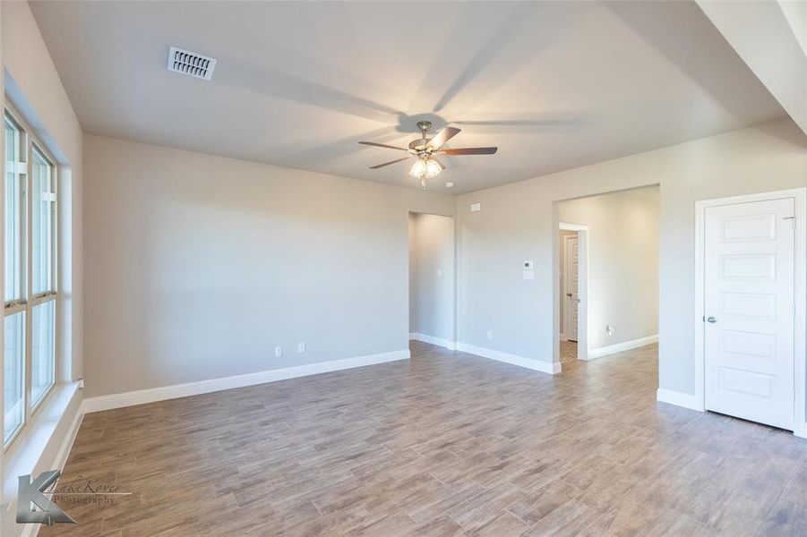 Empty room featuring light wood-style flooring and a ceiling fan