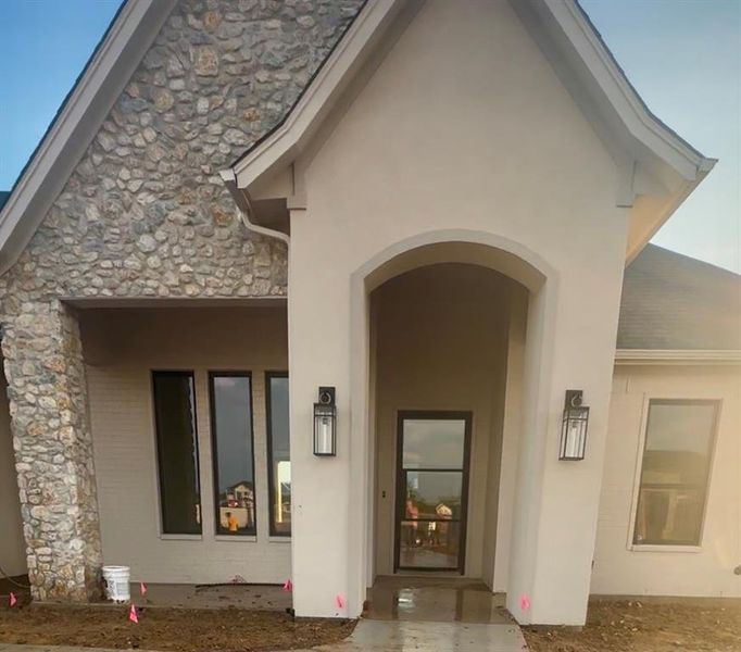 Stucco, Stone and Brick with the glass and steel of the door make for a mix of elements pleasing to any eye!