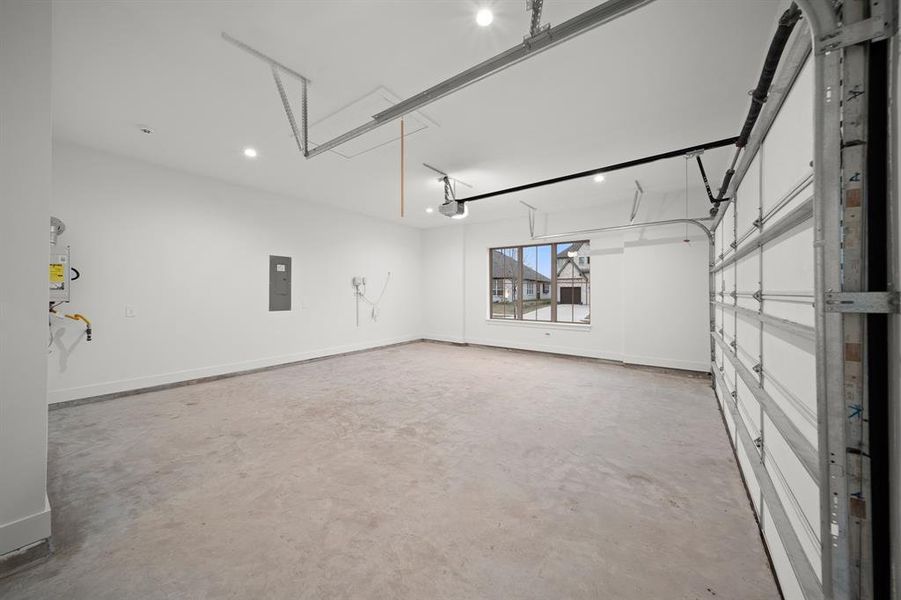 Garage with electric panel and baseboards