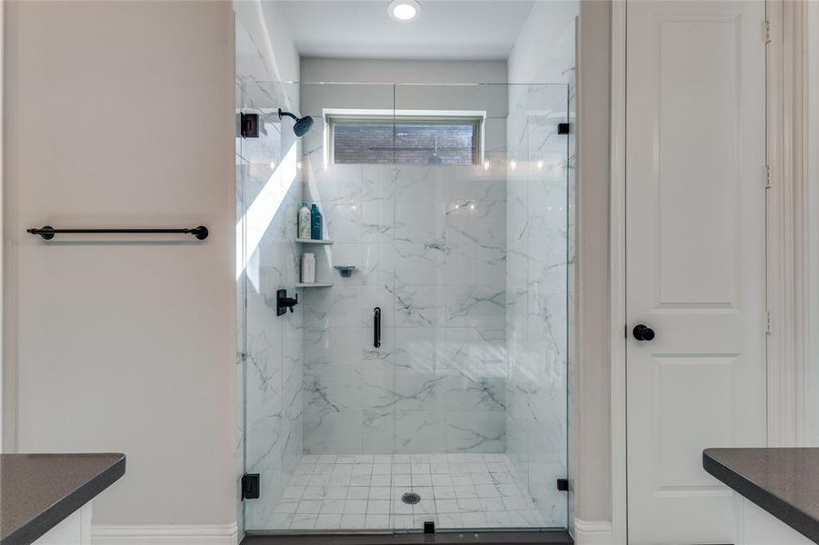 Full bathroom featuring vanity and a marble finish shower