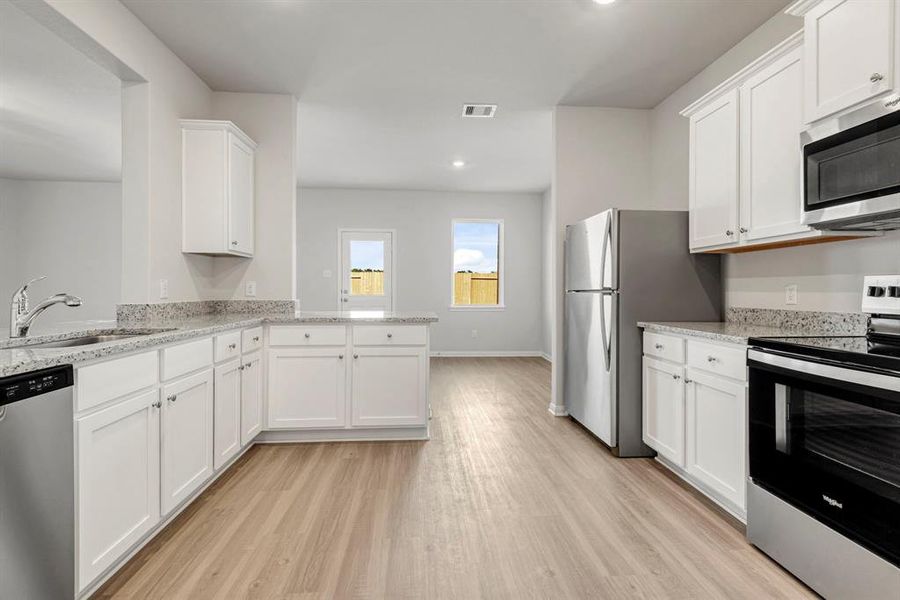 The large kitchen and dining area have upgraded cabinets, granite countertops and energy efficient Whirlpool appliances.