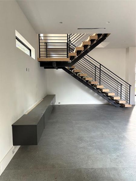 Down Stairs living area with open stairway. Cabinet with access to place all devices and playstation in drawers under TV or Art area,  Surround sound speakers