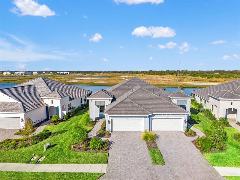 Front exterior of a new home in Palm Grove, Lakewood Ranch, FL, highlighting curb appeal (Image 26). Front exterior of a new home in Palm Grove, Lakewood Ranch, FL, highlighting curb appeal (Image 26).
