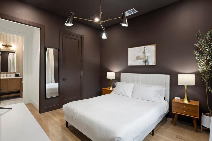 Bedroom with wood-finish flooring and deep brown walls