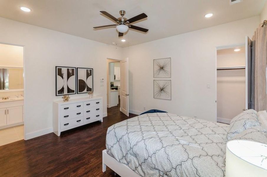 Bedroom with ensuite bath, ceiling fan, dark hardwood / wood-style floors, a closet, and a walk in closet