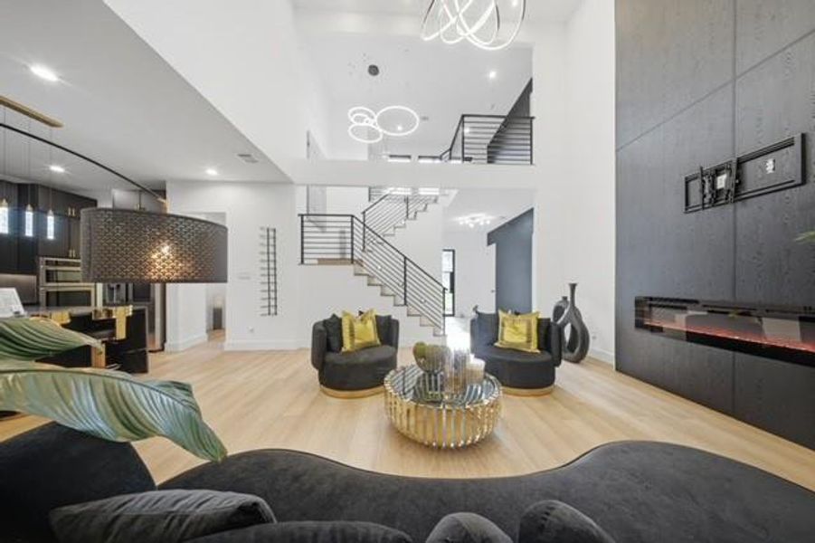 Open-concept living area featuring high ceilings and light wood-finish flooring