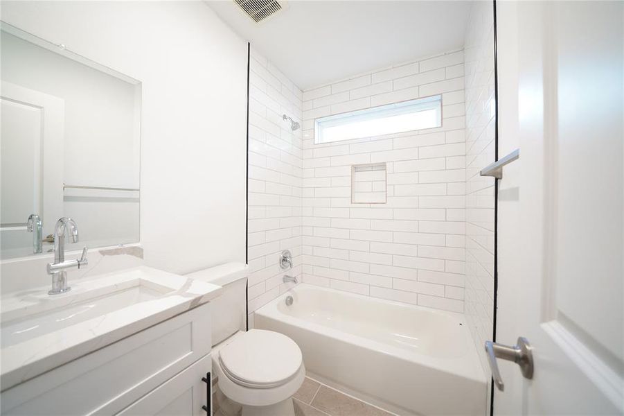 Full bathroom featuring bathtub / shower combination, vanity, and light tile patterned floors