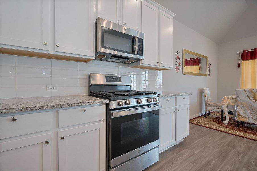 Modern kitchen with granite countertops and oven.