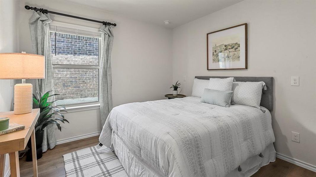Bedroom with light-colored walls and wood-look flooring