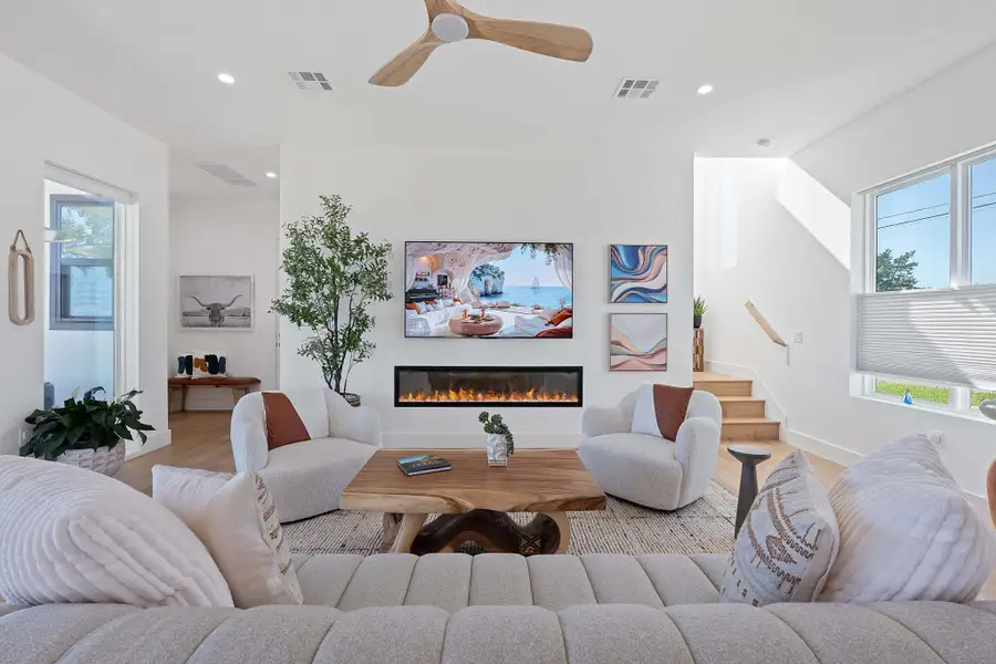 A living room that invites you to settle in, open concept comfort with modern lines and warm natural tones. High Ceilings. A living room that invites you to settle in, open concept comfort with modern lines and warm natural tones. High Ceilings.