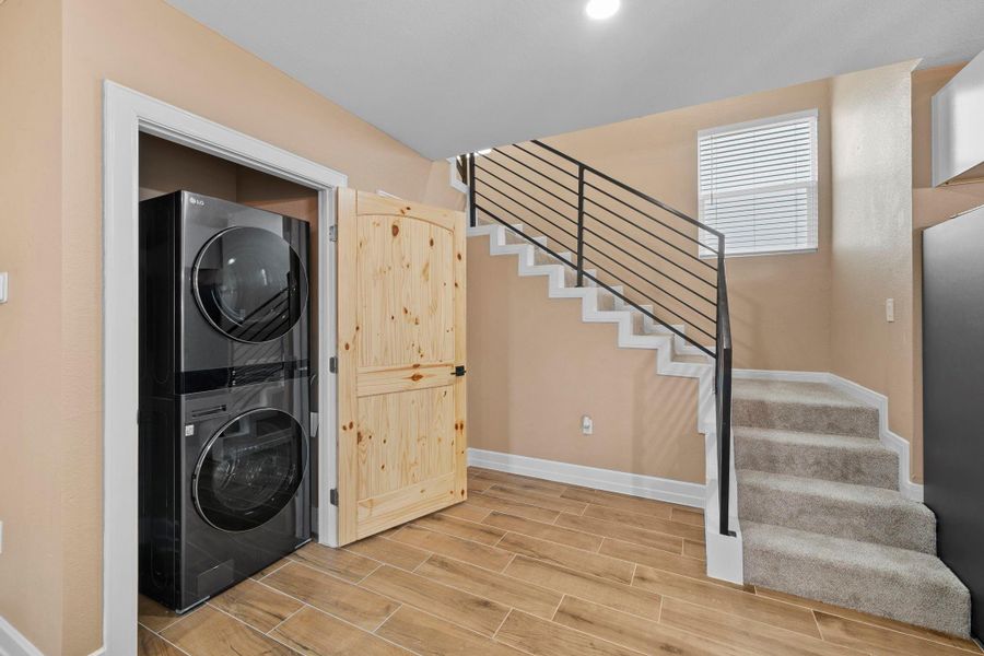 Life is just easier when your laundry space is as beautiful as the rest of your home. Conveniently situated on the main level next to the carpeted stairs, this built-in utility area is hidden away by a stunning natural wood barn door.