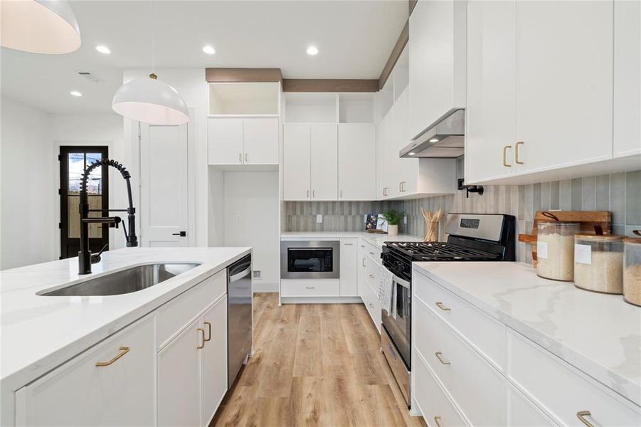 Sleek thin shaker style design in the cabinetry offers ample storage with soft-close drawers and stylish hardware.