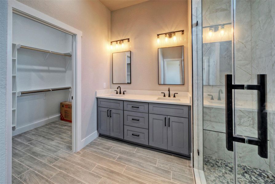 Clean lines and stone counters highlight this master bathroom featuring a dual vanity and glass shower. Clean lines and stone counters highlight this master bathroom featuring a dual vanity and glass shower.