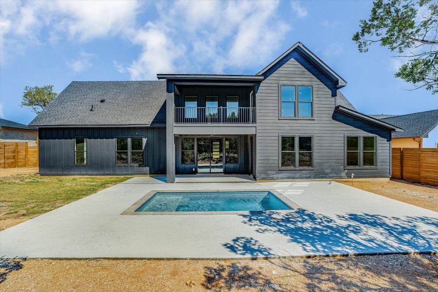 An inviting backyard oasis awaits with a pristine inground pool and an upper-level balcony for elevated views.