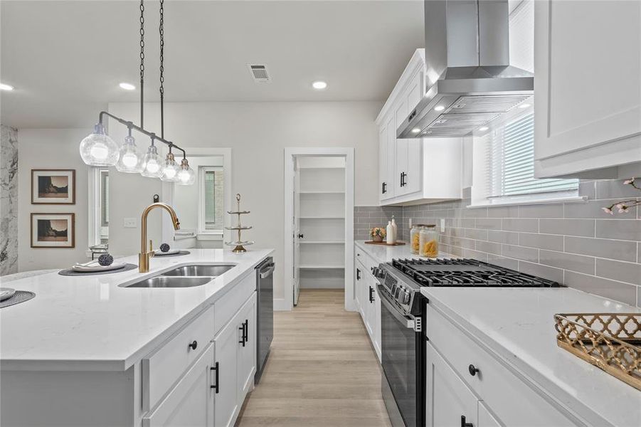 Kitchen with white cabinetry, stainless steel appliances, a center island with sink, light stone counters, and recessed lighting Kitchen with white cabinetry, stainless steel appliances, a center island with sink, light stone counters, and recessed lighting