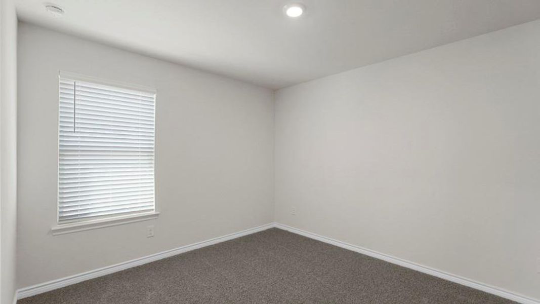 Neutral-toned interior with a window featuring horizontal blinds, recessed lighting, and grey textured carpeting
