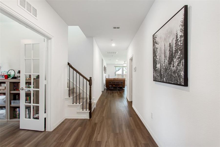 Corridor featuring dark wood finished floors and stairway