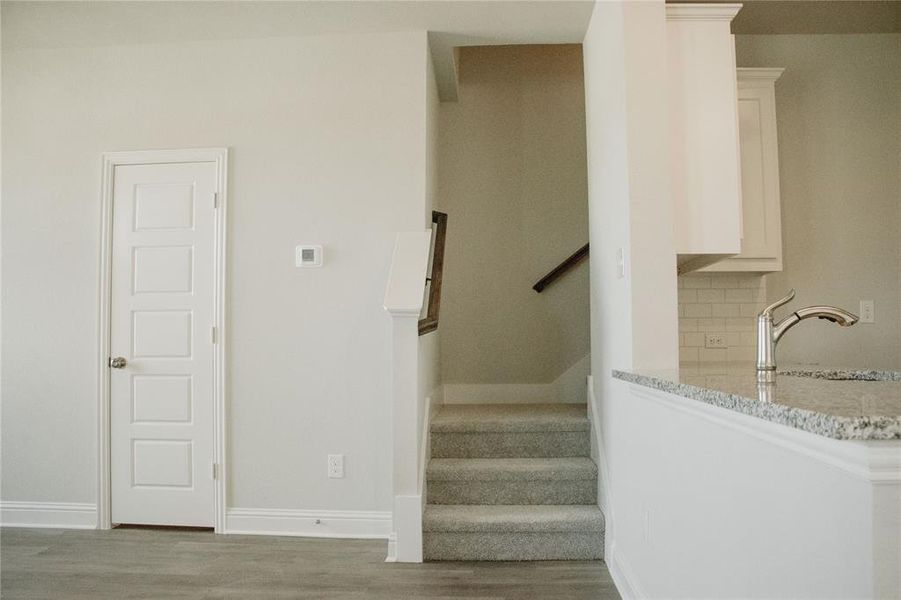 Stairs with sink and hardwood / wood-style flooring