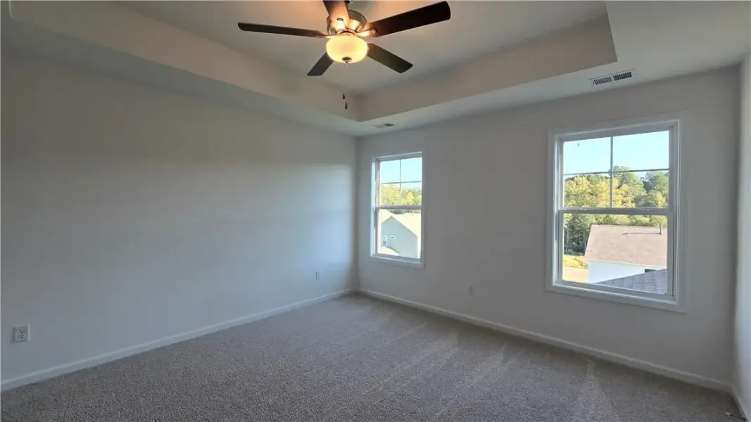 A tray ceiling pairs with soft carpeting in this c