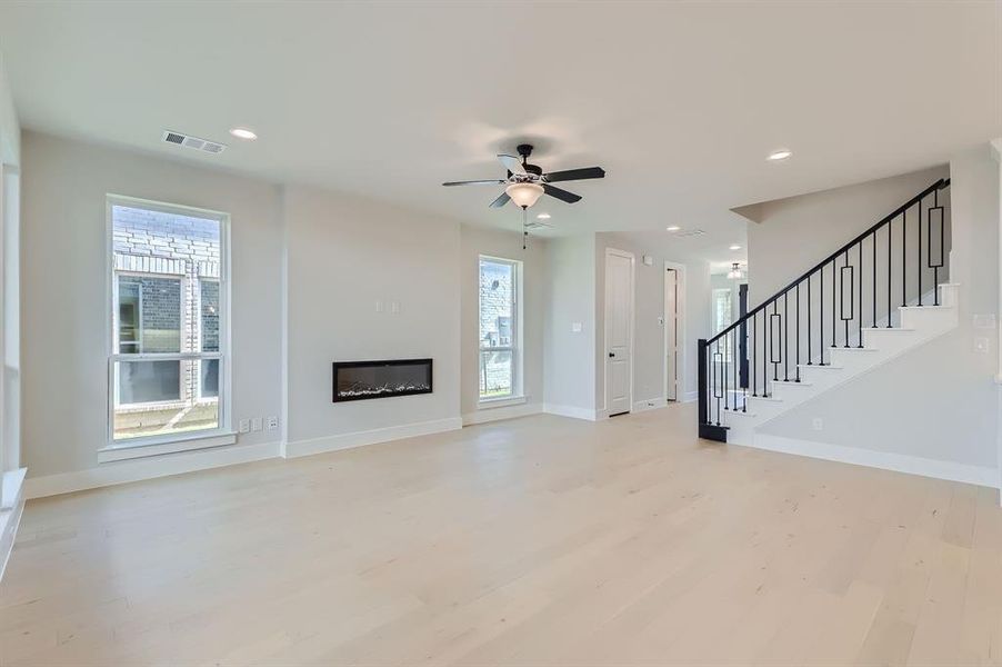 Unfurnished living room featuring light hardwood / wood-style flooring and ceiling fan