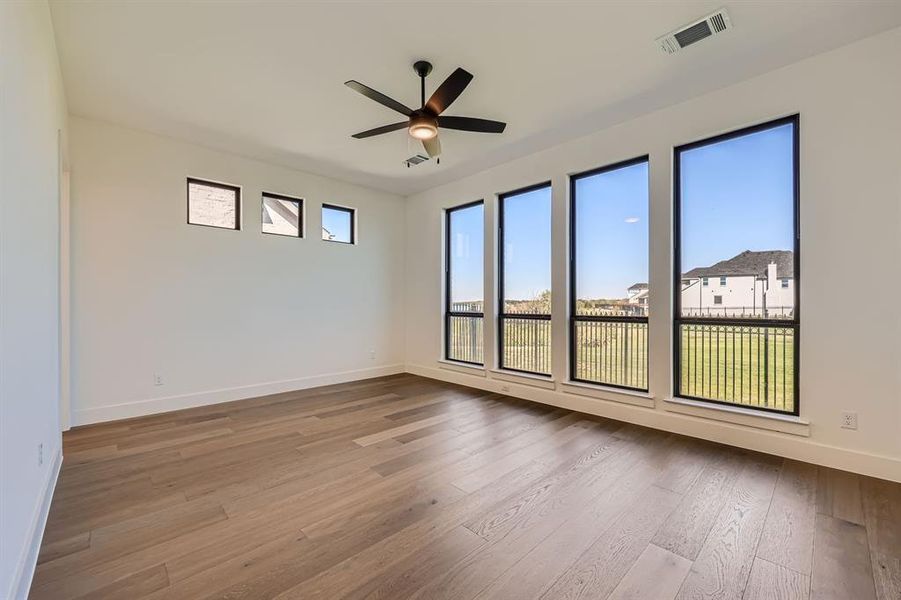 Empty room with hardwood / wood-style floors and ceiling fan