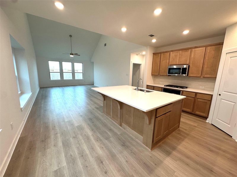 The kitchen features beautiful cabinetry, a large center island, and abundant natural light from surrounding windows, creating a warm and inviting space for gathering and entertaining.