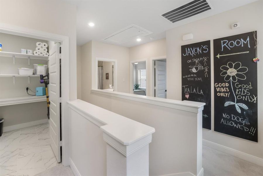 Hallway featuring attic access, light marble finish flooring, an upstairs landing, and recessed lighting