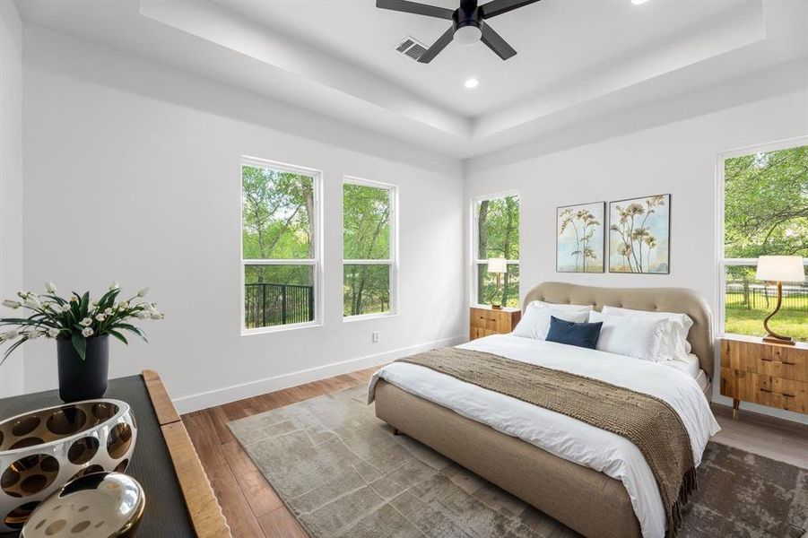 Primary bedroom with large windows, high ceilings, and a serene nature view!