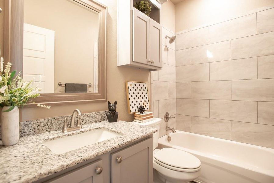 Bathroom featuring toilet,  shower combination, and vanity
