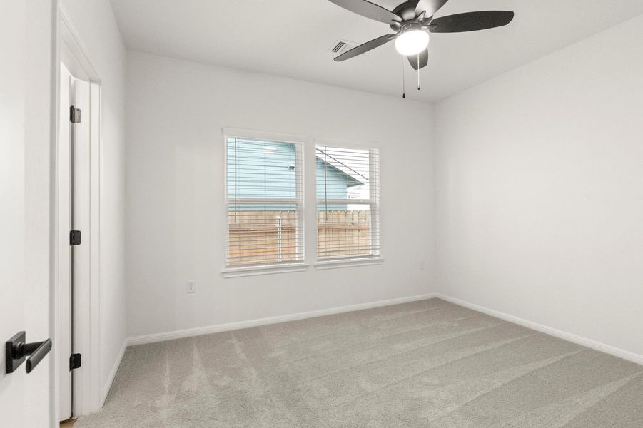 Spare room featuring light carpet and ceiling fan