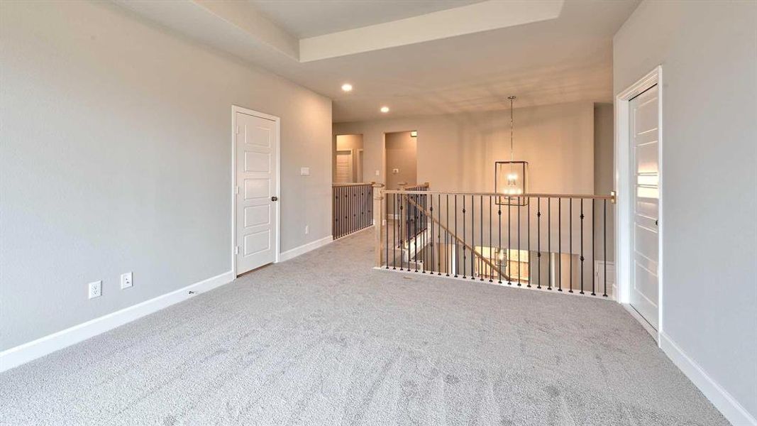 Carpeted room featuring a tray ceiling