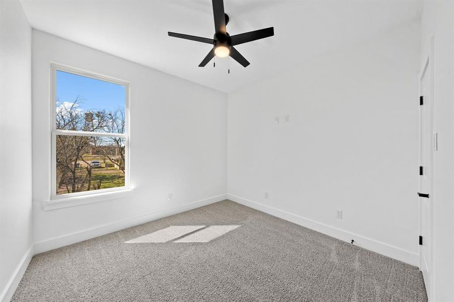 Spare room with ceiling fan, carpet, and baseboards